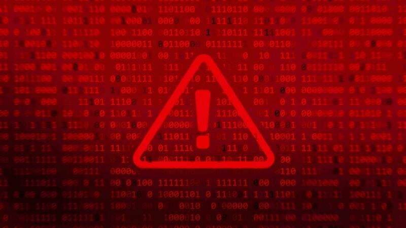 Red warning triangle with an exclamation mark over a background of digital code, signaling a cybersecurity alert.